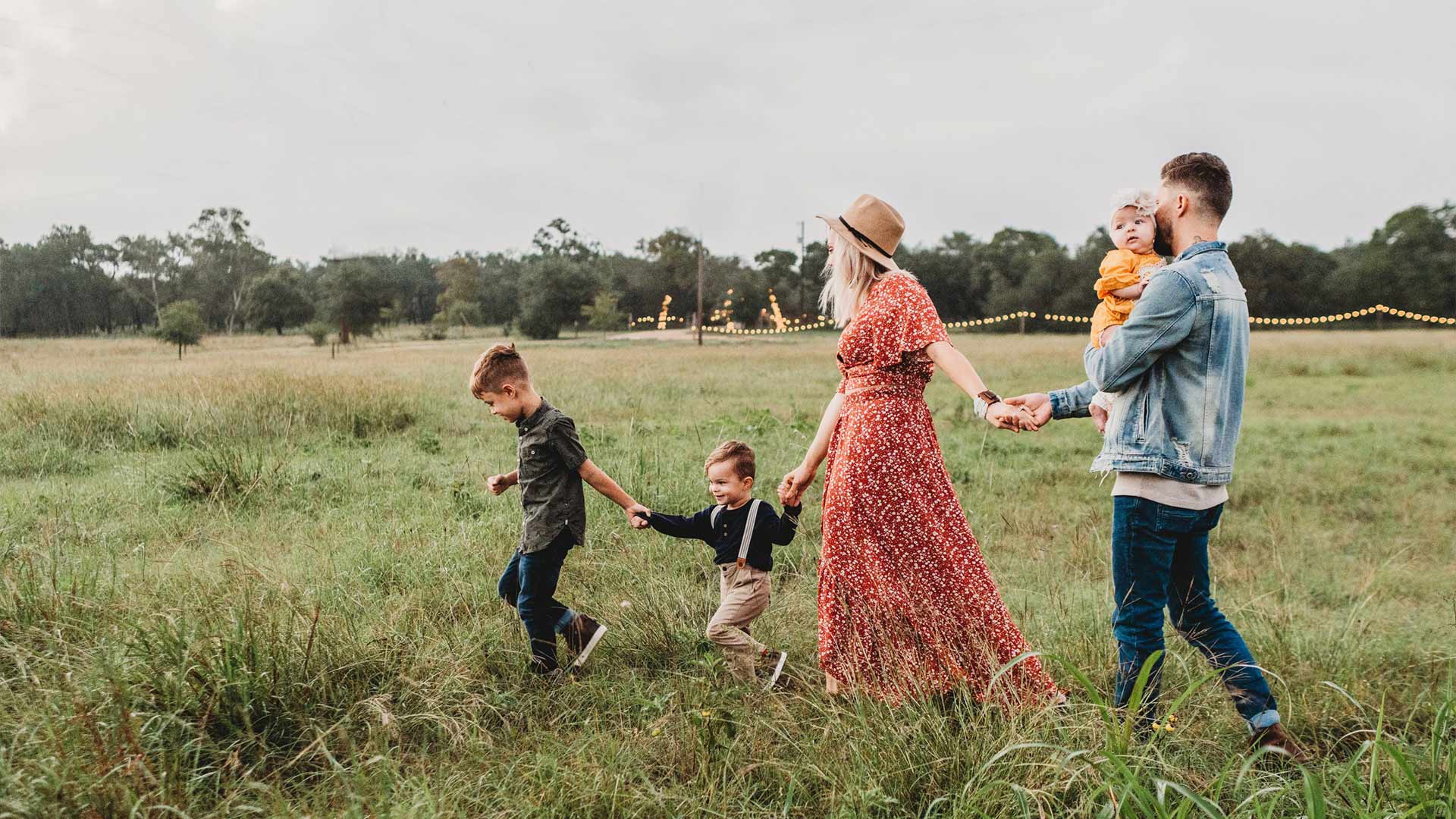 A family walking through a grassy meadow.